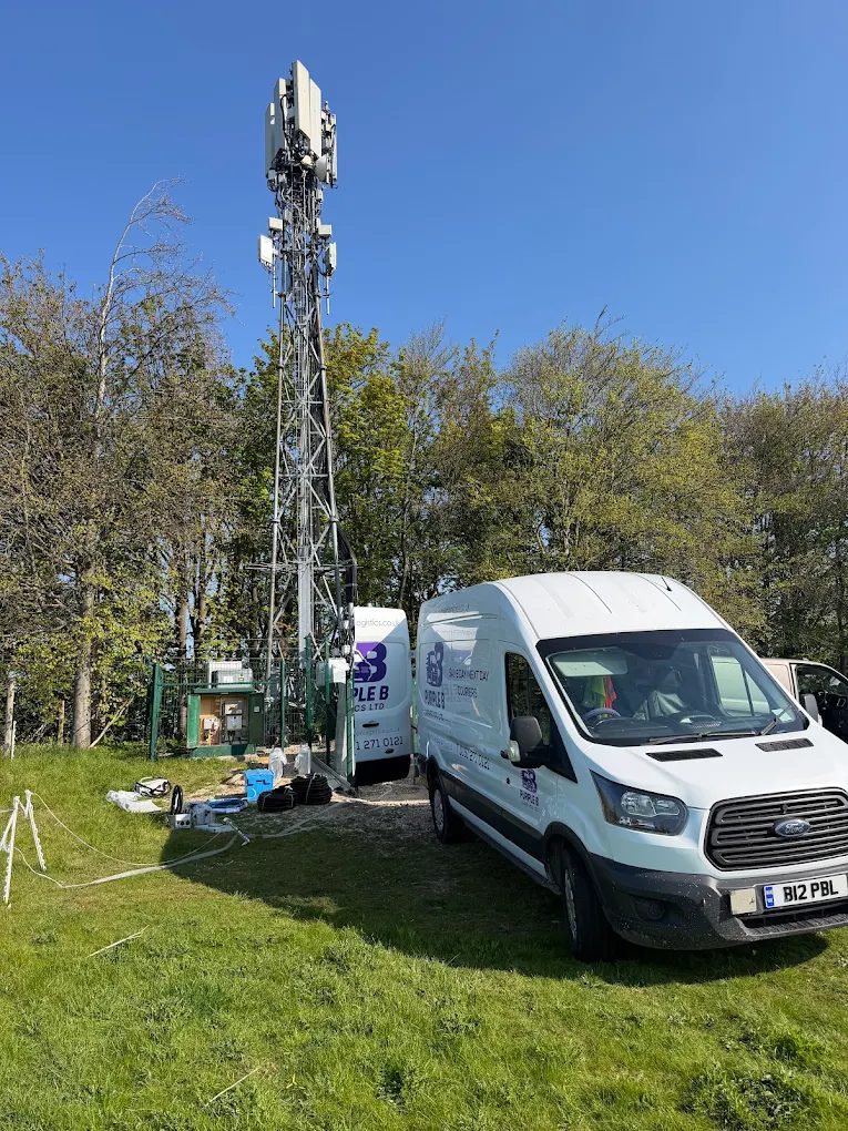 Telecoms mast with site equipment and cabling delivered at its base